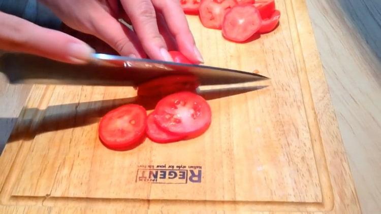 За да направите пържоли от розова сьомга, нарежете доматите