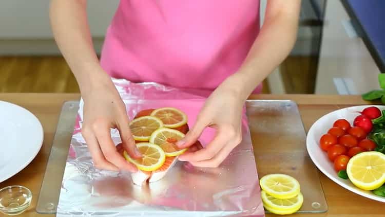 Για να προετοιμάσετε ένα παλάκι σολομού στο φούρνο, βάλτε το λεμόνι στο μπριζόλα.