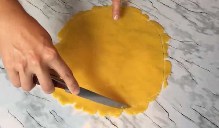 لعمل بسكويت بالجبنة ، قم بطرح العجين