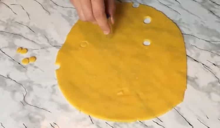 Chcete-li vyrobit sýrové sušenky, vytvořte do těsta díry