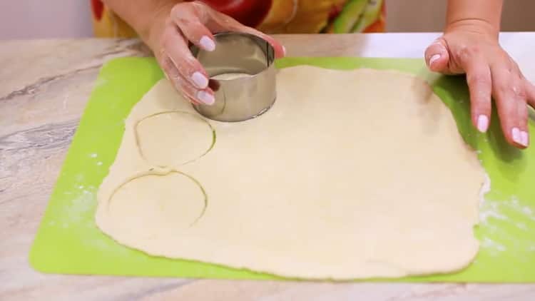 Για να προετοιμάσει τα μπισκότα τυρί cottage, τα πόδια χήνας ξεδιπλώσουν τη ζύμη