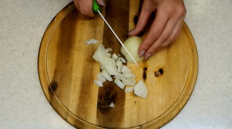 Per cucinare i crauti in umido, tritare la cipolla