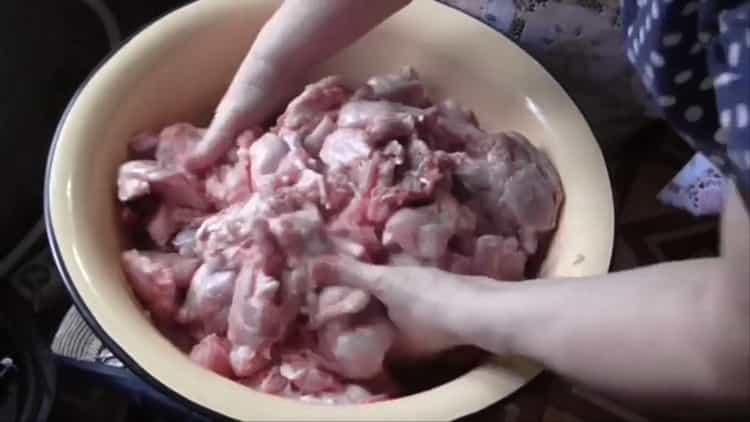 Per fare lo stufato di coniglio, tagliare la carne