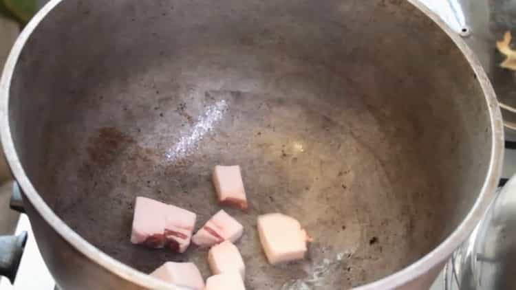 За да направите узбекски пилаф от свинско месо, запържете мазнини