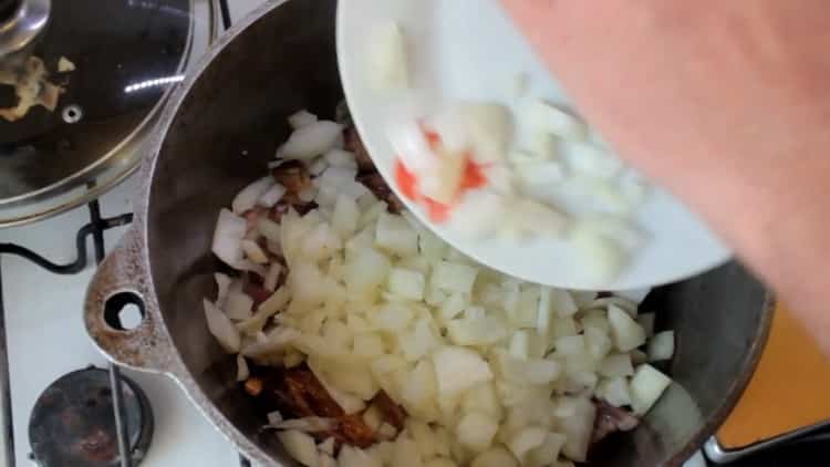 لجعل بيلاف الأوزبكي من لحم الخنزير ، يقطع البصل