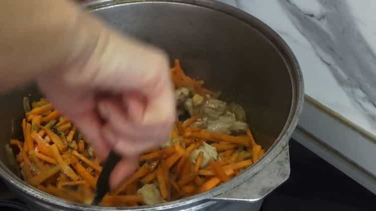 Zum Kochen von usbekischem Pilaw mit Hühnchen die Zutaten anbraten