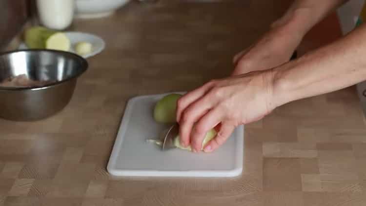 Нарежете лука, за да направите пилешки феттучини.