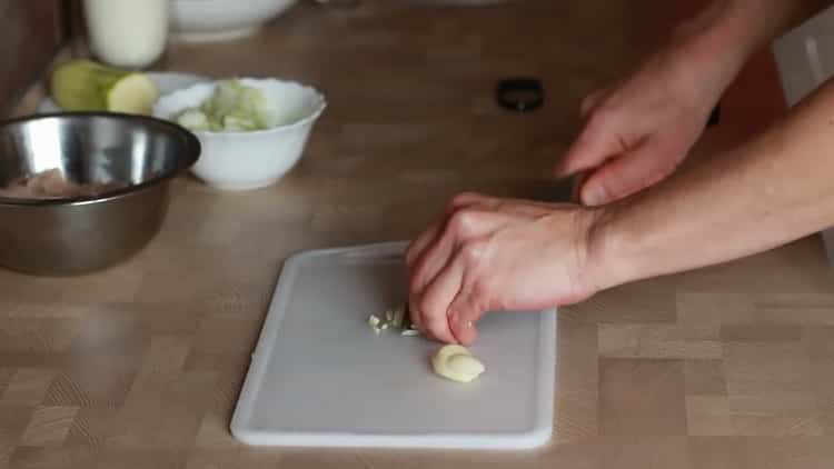 Knoblauch hacken, um Fettuccini mit Huhn zu machen