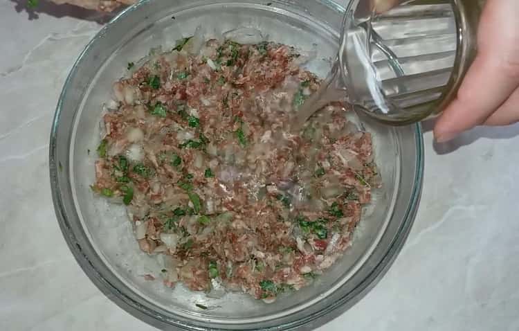 Per preparare il khinkali secondo una semplice ricetta con una foto, aggiungi acqua alla carne macinata