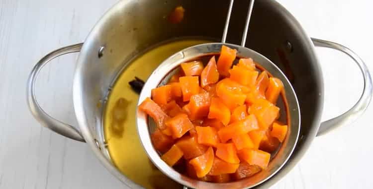 Um zu Hause kandierte Kürbisfrüchte zuzubereiten, lassen Sie den Sirup abtropfen