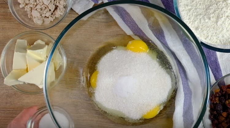 Į kiaušinius įpilkite cukraus ir vanilinio cukraus.