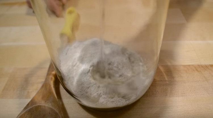 Τοποθετήστε το αλεύρι σίκαλης σε ένα βάζο και προσθέστε ζεστό νερό σε αυτό.