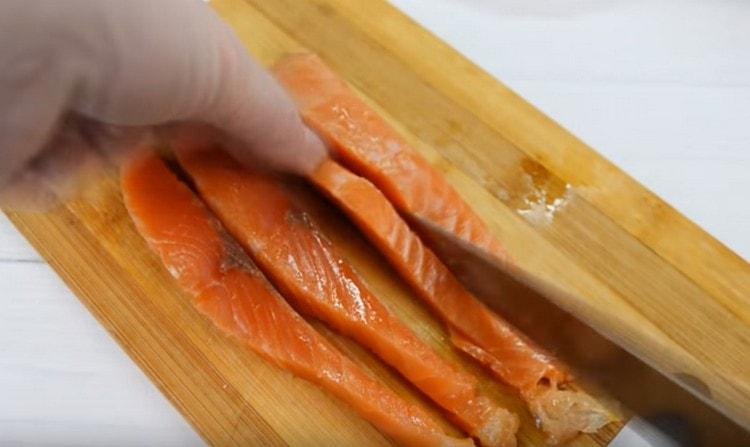 Tagliare il filetto di salmone a fette lunghe.