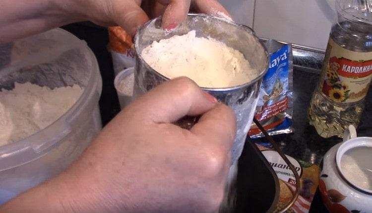 Setacciare la farina direttamente in un secchio di una macchina per il pane.