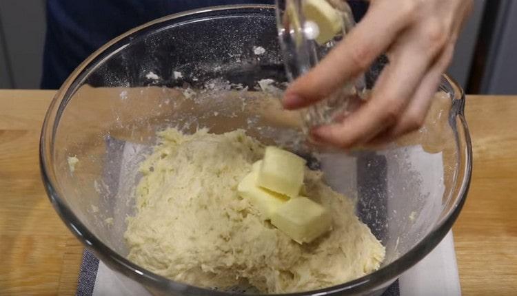Do lepkavého těsta přidejte máslo.