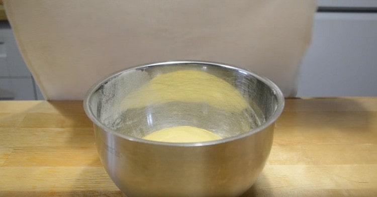 Разпределяме тестото в купа, поръсена с брашно и оставяме да втаса на топло място.