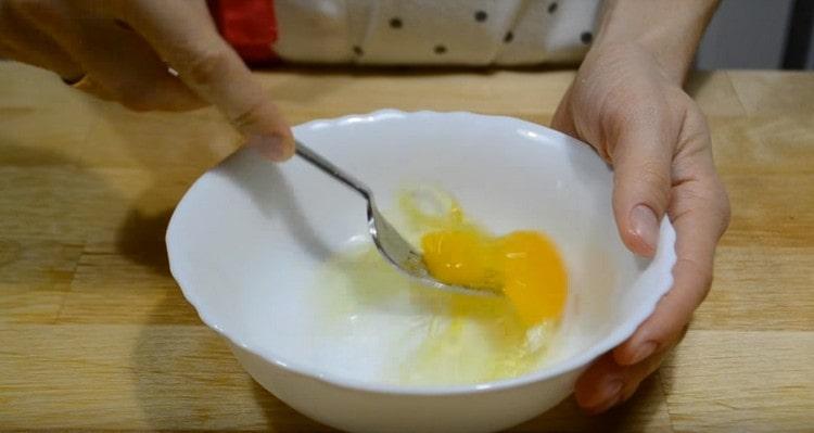Sbattere l'uovo con una forchetta.