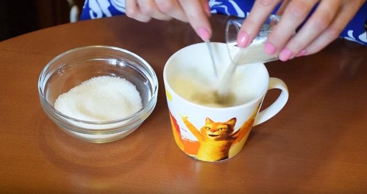 Към топло мляко добавяме мая и захар.