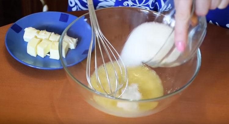 Σε ένα μπολ, συνδυάστε το αυγό με ζάχαρη και αλάτι.