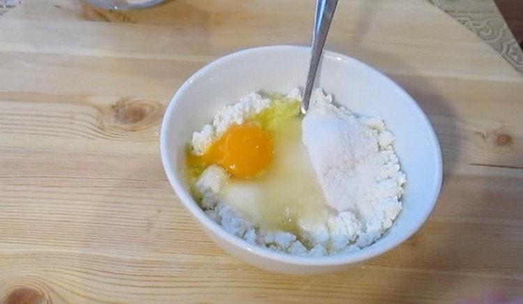 Προσθέτουμε το αυγό και τη ζάχαρη στο τυρόπηγμα. ζάχαρη βανίλιας.