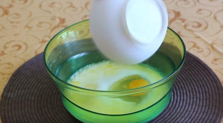 In die Milch Salz, Zucker, ein Ei sowie zerlassene Butter geben.