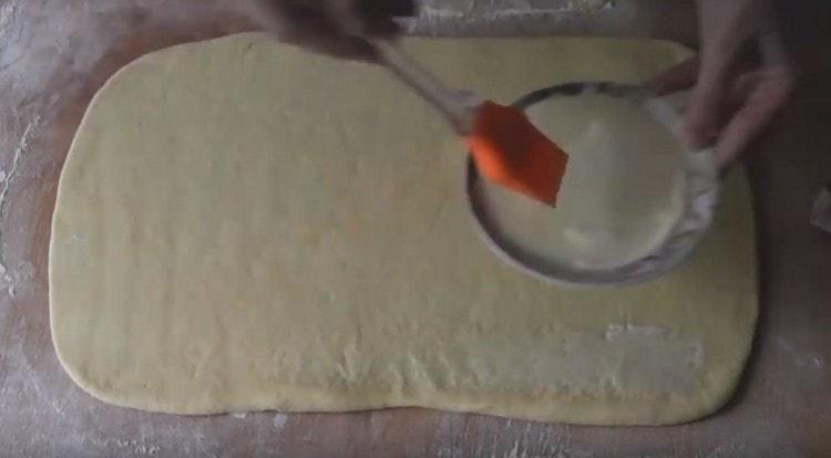Tešlos sluoksnį sutepkite tirpintu sviestu.