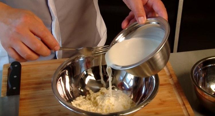 Adjunk hozzá zsíros tejszínt a sajthoz és keverjük össze.