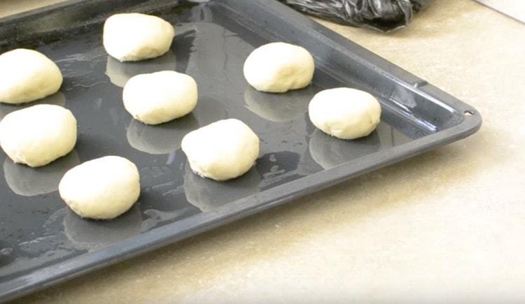 Разпределяме топките тесто върху лист за печене, намазан с растително масло.
