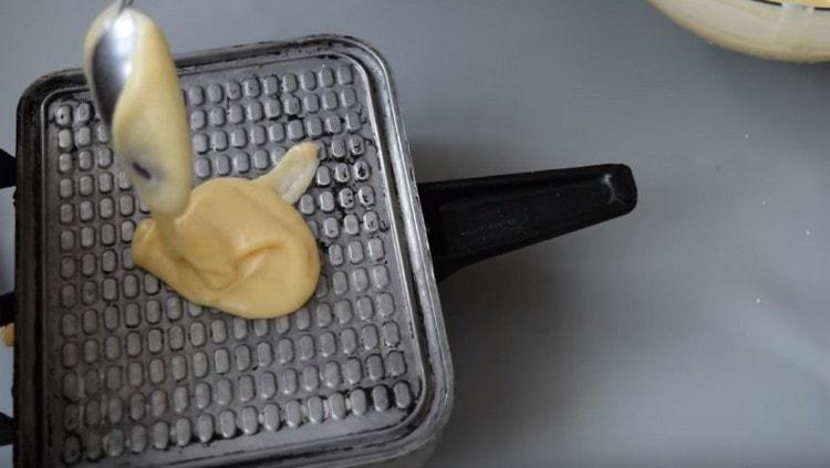 Distribuire un cucchiaio di pasta in un waffle e friggere i waffle.
