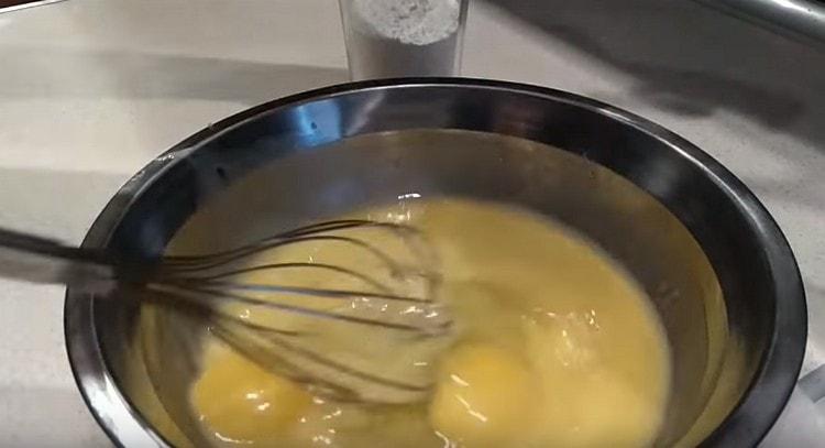 Προσθέστε δύο αυγά στο βούτυρο και χτυπήστε με ένα χτύπημα.