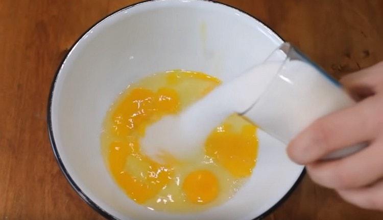 Zucker zu den Eiern geben.