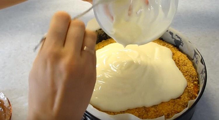 Versare la cheesecake calda con una miscela di latte condensato e panna acida.