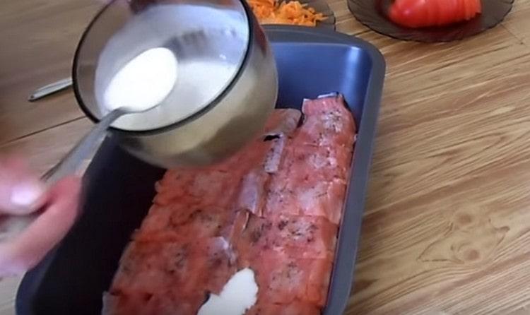 Поставете парчетата риба във формата, залейте с млечно-заквасения сос.