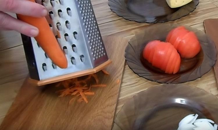 Σε ένα χοντρό τρίφτη τρίβουμε τα καρότα.