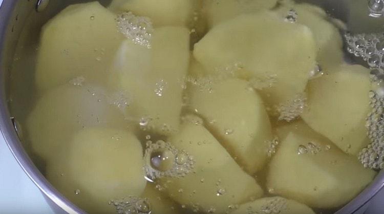 Wir putzen die Kartoffeln, waschen sie, schneiden sie in Stücke und kochen sie.