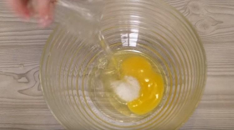 Į kiaušinį įpilkite druskos ir augalinio aliejaus.
