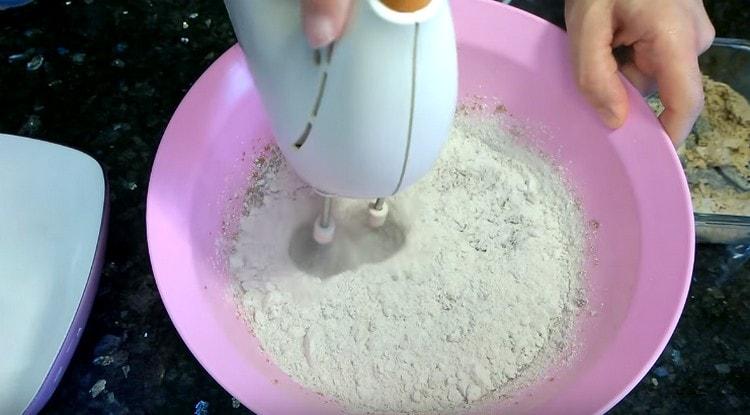 Mescolando la massa con un mixer, aggiungere la farina.