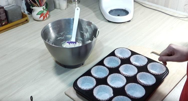 Inserire i dischetti di carta nella teglia per cupcake.