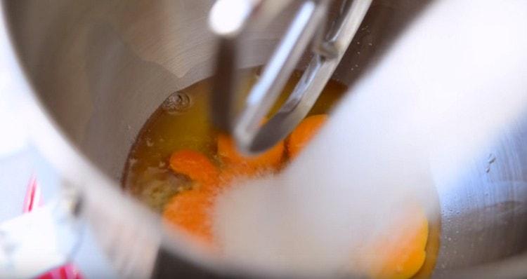 In der Schüssel des Mixers die Eier schlagen, Zucker einschenken.