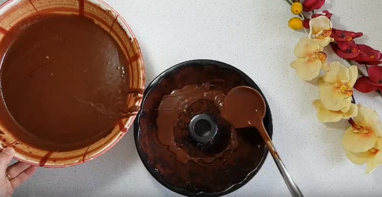 Gießen Sie den Teig in eine große Form, die Sie zuerst mit Öl einfetten und mit Kakao bestreuen müssen.