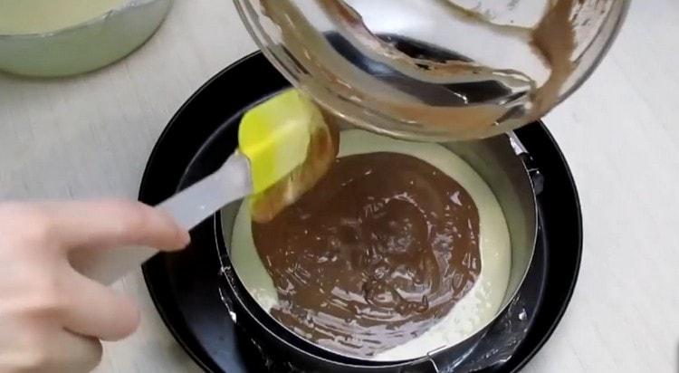 Į riebalais išteptą kepimo indą pakaitomis supilkite baltą ir šokoladinę tešlą.