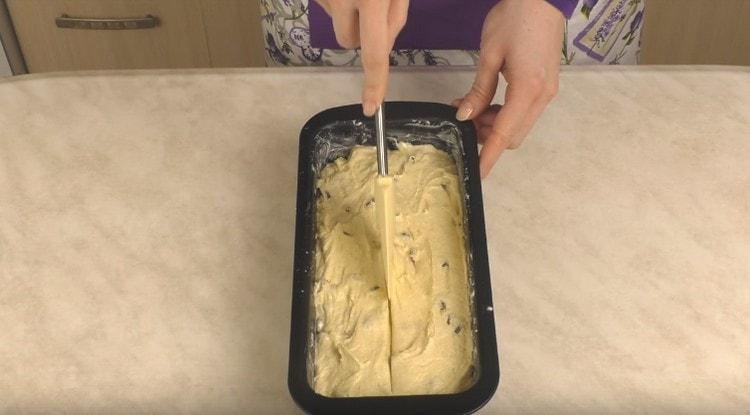 Szétterítjük a tészta formáját, kiegyenlítjük, és közepén metszzük be egy nedves spatulakkal.