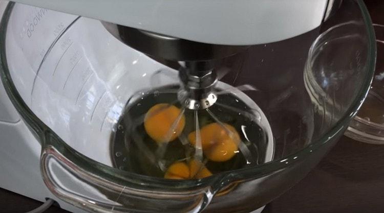 A keverő táljában verje be a tojásokat és verje be.