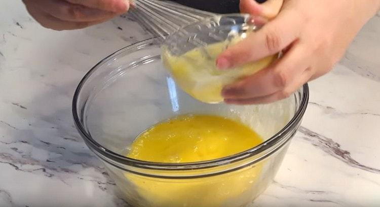 Προσθέστε μαλακό βούτυρο στη μάζα των αυγών.