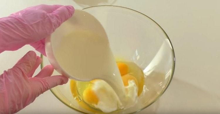 Разбиваме яйцата в купа и добавяме мляко.