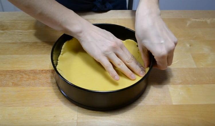 Da un pezzo di pasta più grande, formiamo la suola per la torta.
