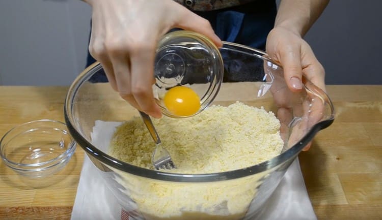 Įpilkite kiaušinio trynį ir sumaišykite masę.