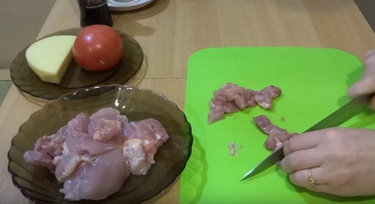 Das Huhn in kleine Stücke schneiden.