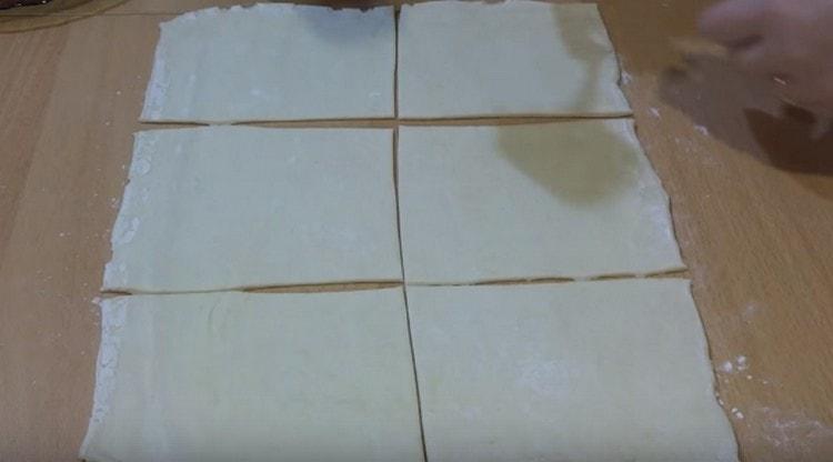 Stendere la pasta sfoglia e tagliarla a quadrati.