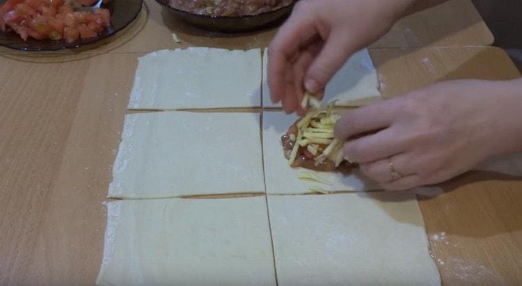Levitämme lihatäyte neliön keskelle, lisää tomaatti ja juusto päälle.